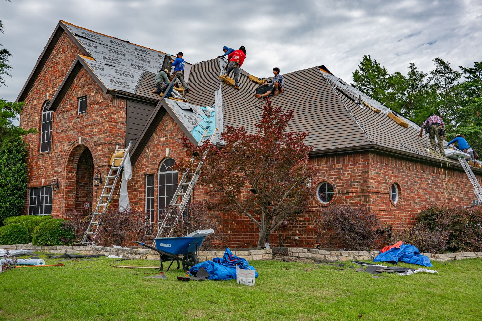 Roofers working on a brick home